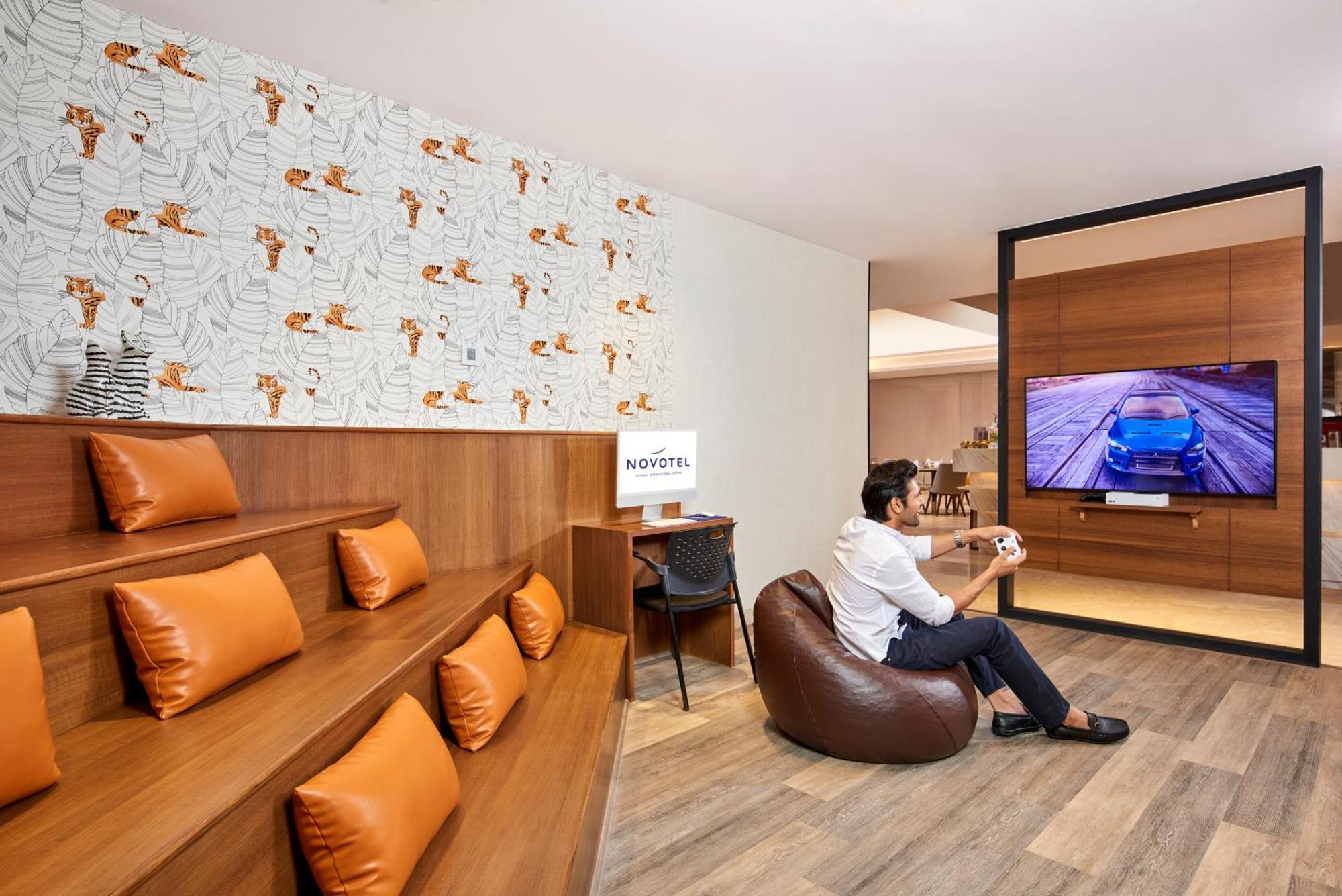 Novotel Mumbai International Airport Dış mekan fotoğraf A man playing a video game at the lounge