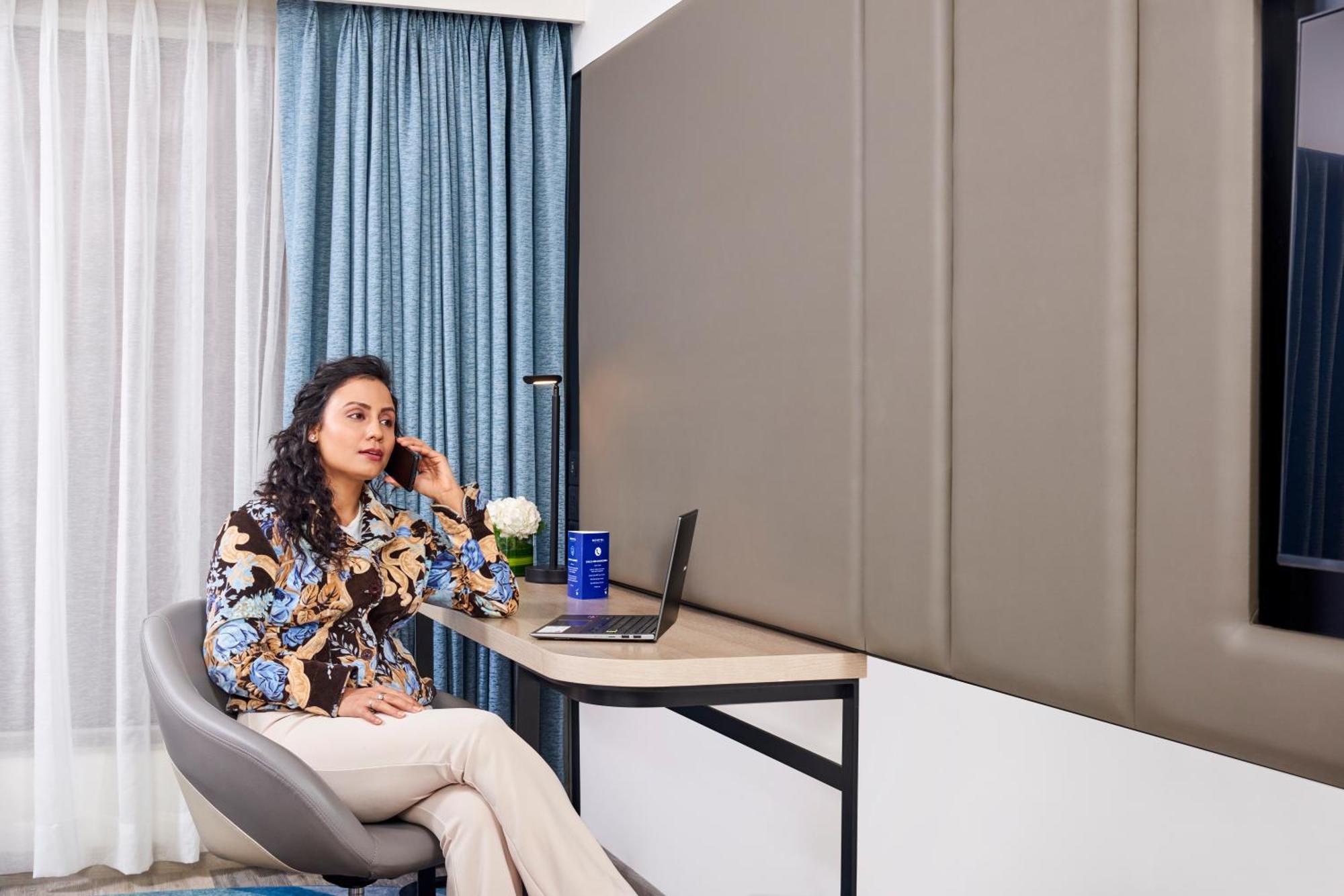 Novotel Mumbai International Airport Dış mekan fotoğraf A woman working from home